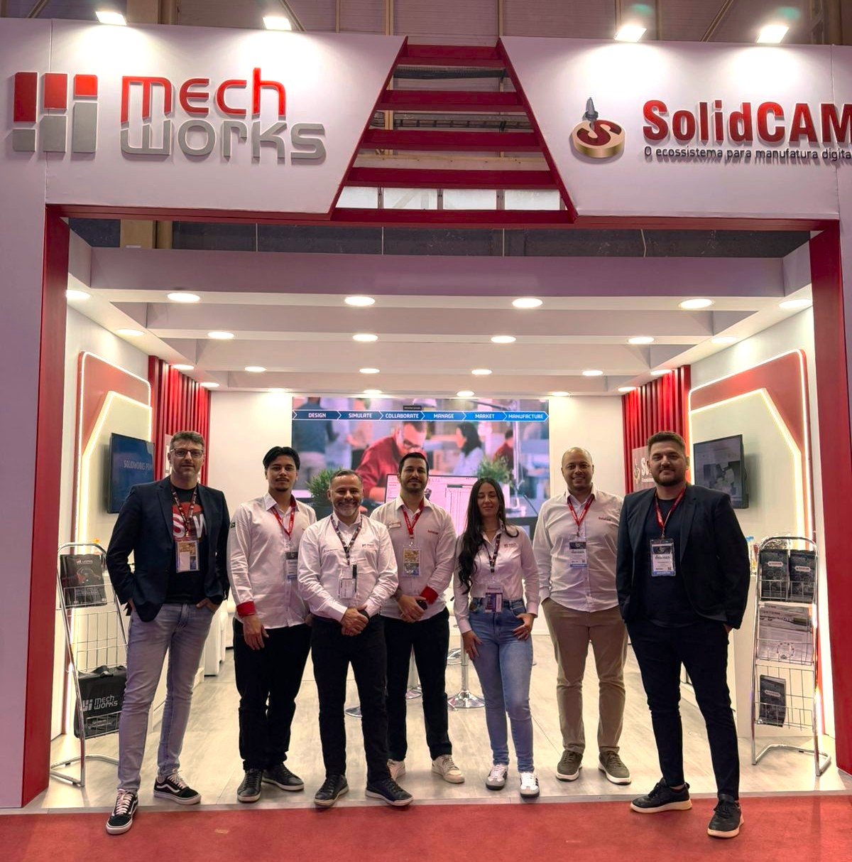 A imagem apresenta membros da equipe MechWorks e da equipe SOLIDCAM em frente ao estande na feira Intermach.