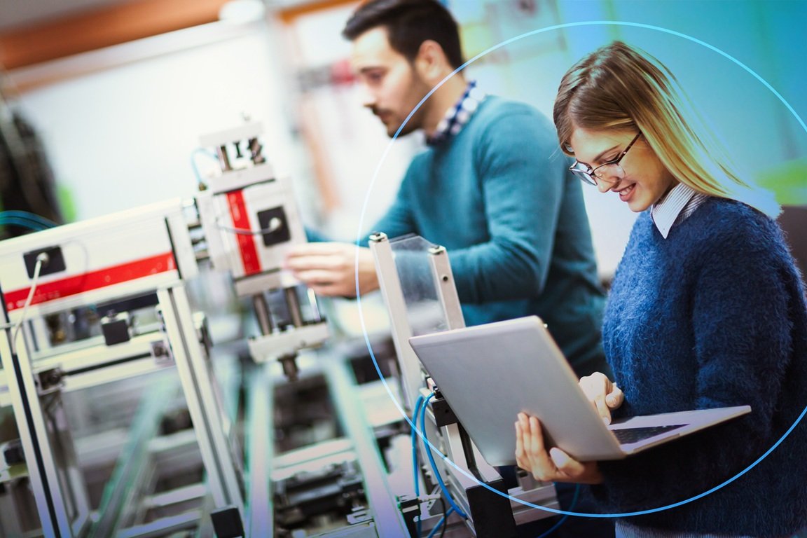 Imagem de mulher segurando um computador, com máquinas à sua frente, representando que ela está utilizando o SOLIDWORKS design for students, SOLIDWORKS gratuito para estudantes.
